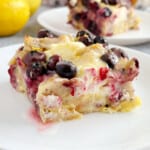 slice of lemon blueberry bagel breakfast casserole on white plate.
