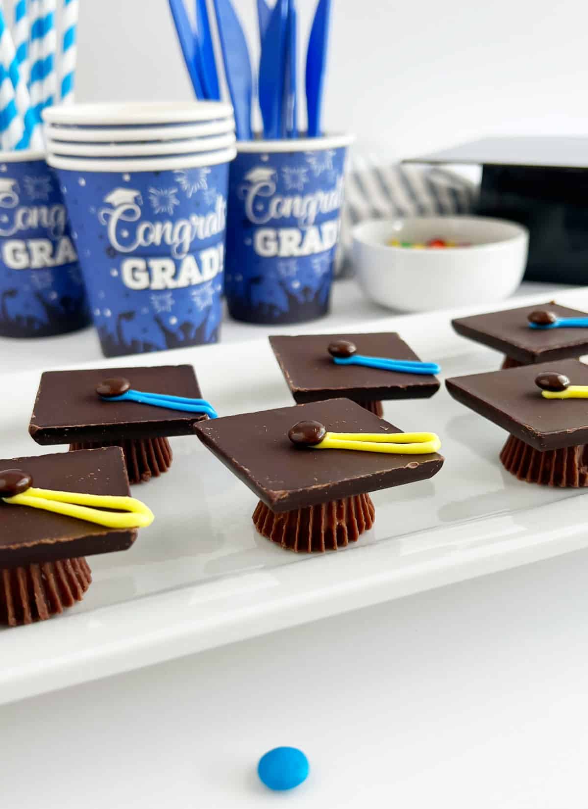 candy graduation caps treats on table with party supplies.