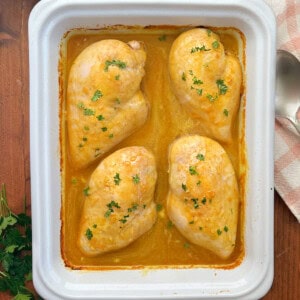honey mustard curry chicken with parsley in baking dish.