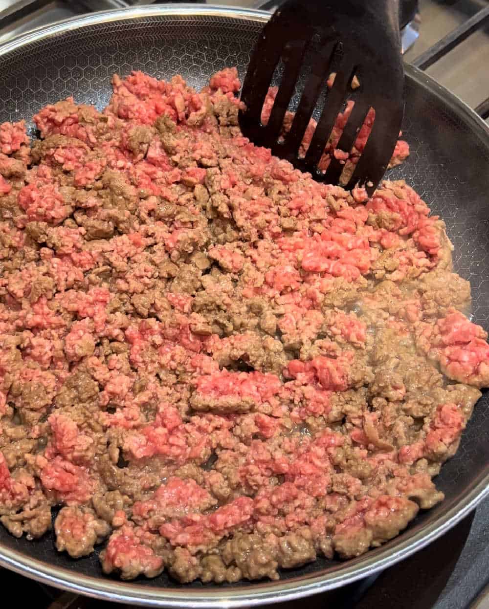 brown hamburger meat in skillet.