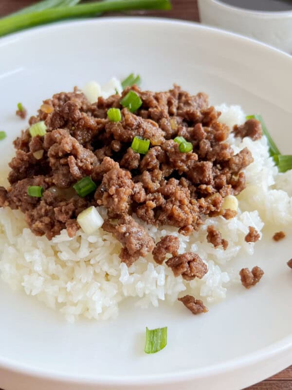 Korean ground beef with green onions over rice on a plate.