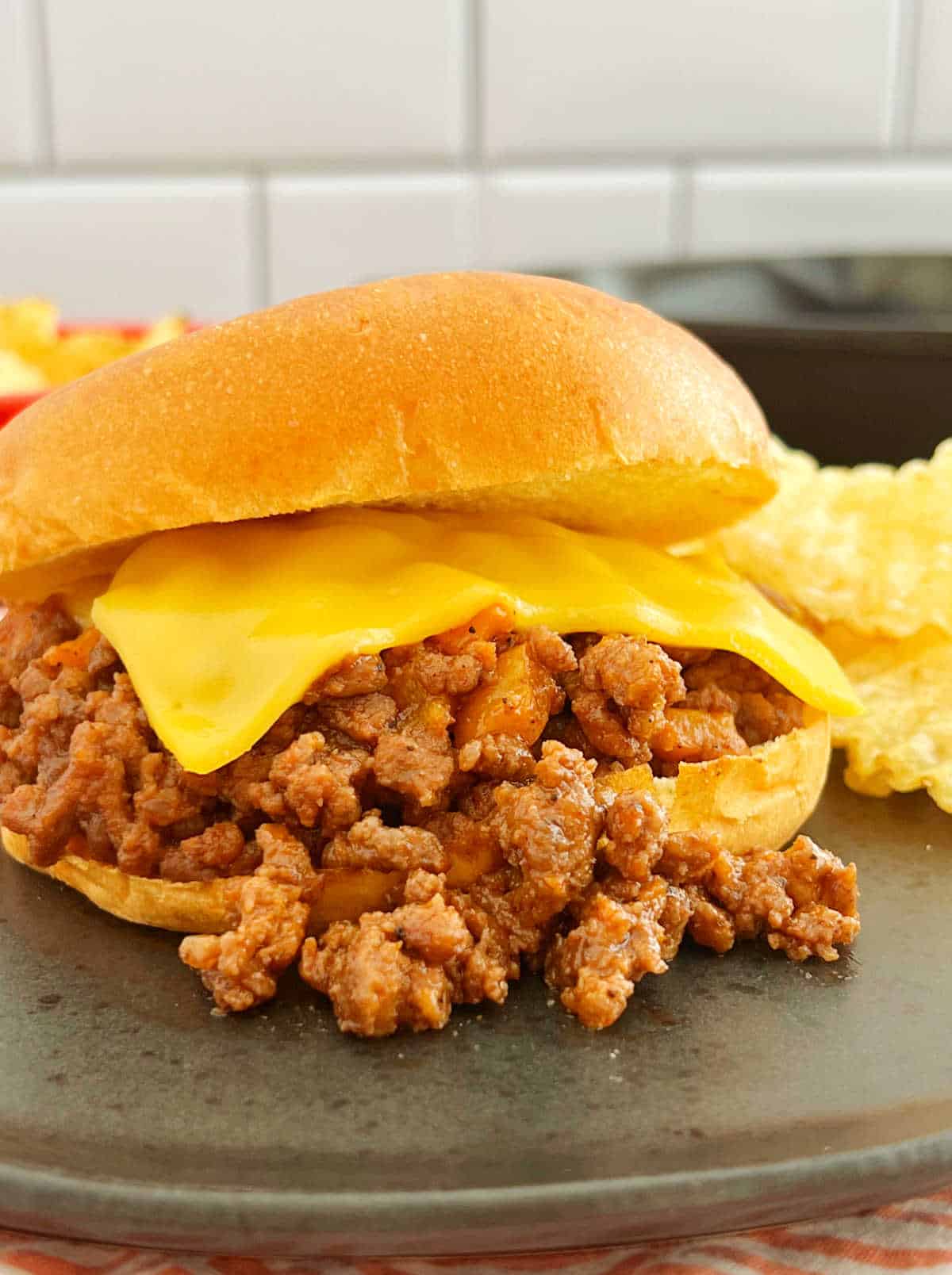 old fashioned sloppy joe sandwich on a plate with slice of cheese.