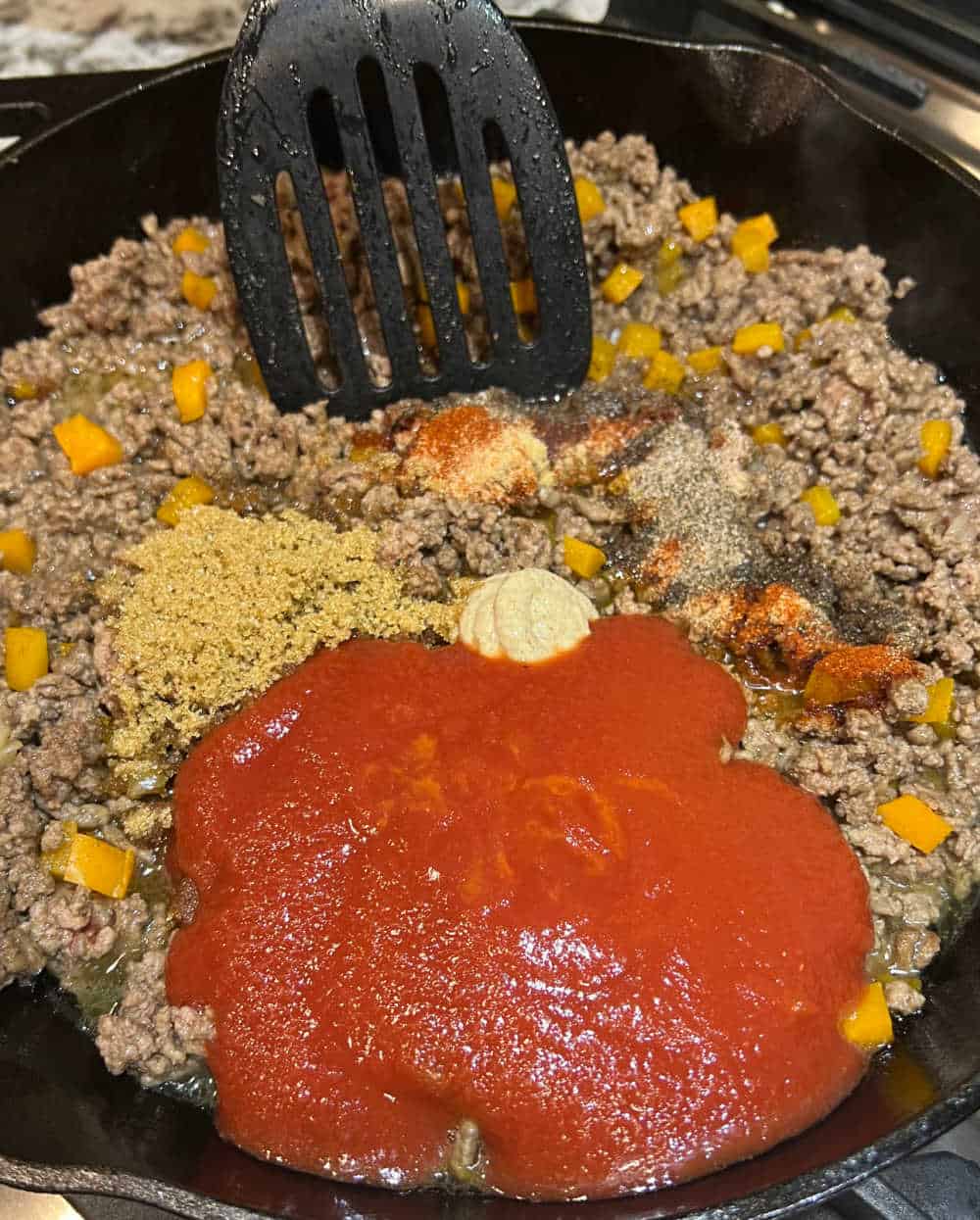 cook hamburger meat with tomato sauce in skillet.