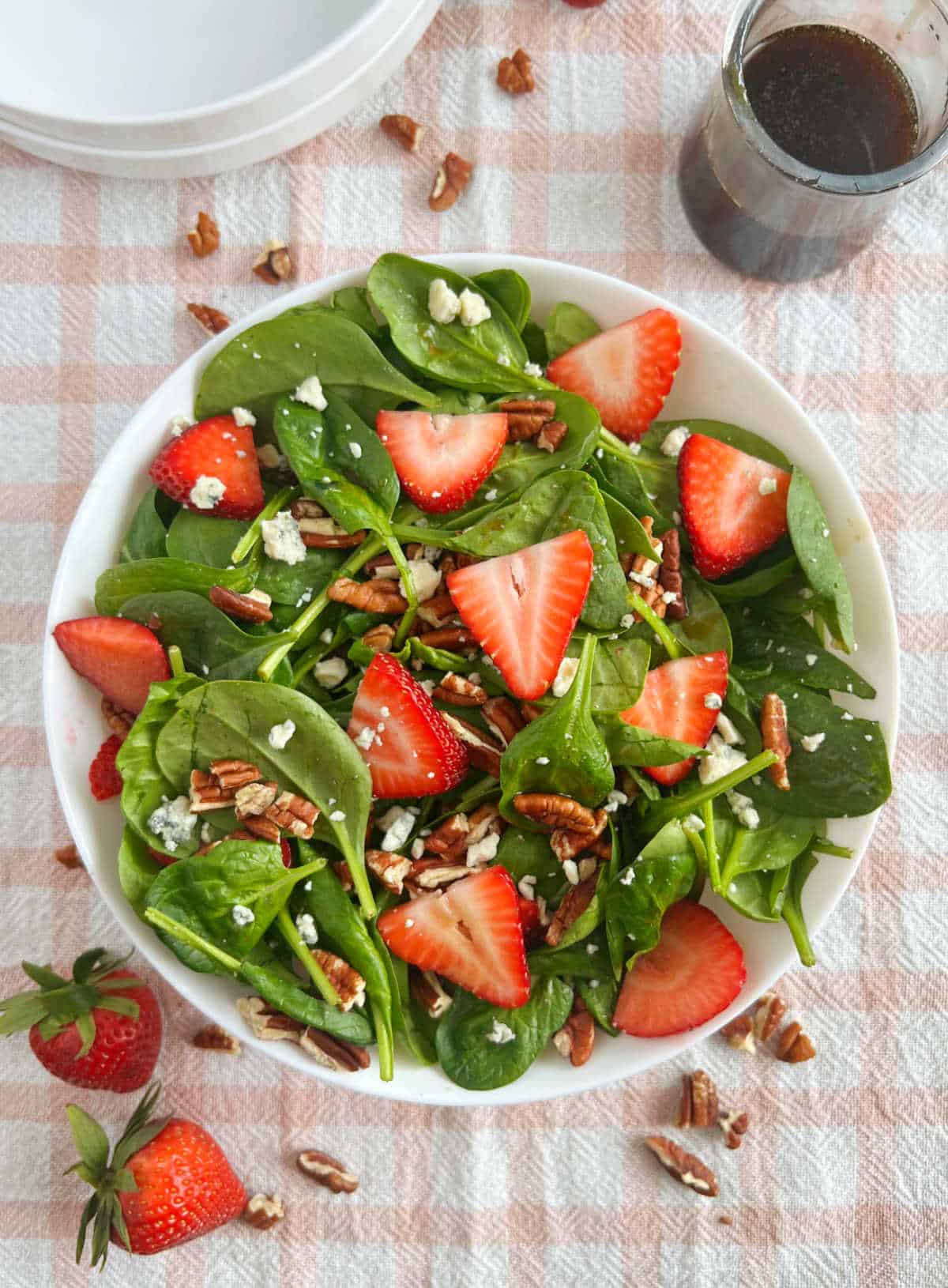 spinach salad with strawberries, gorgonzola cheese and pecans on the table.