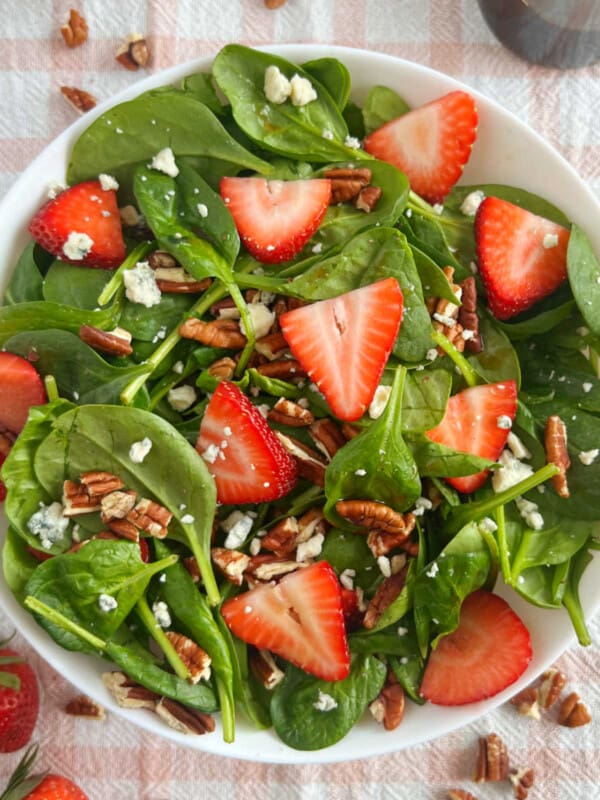 bowl of strawberry spinach salad with gorgonzola cheese and pecans.