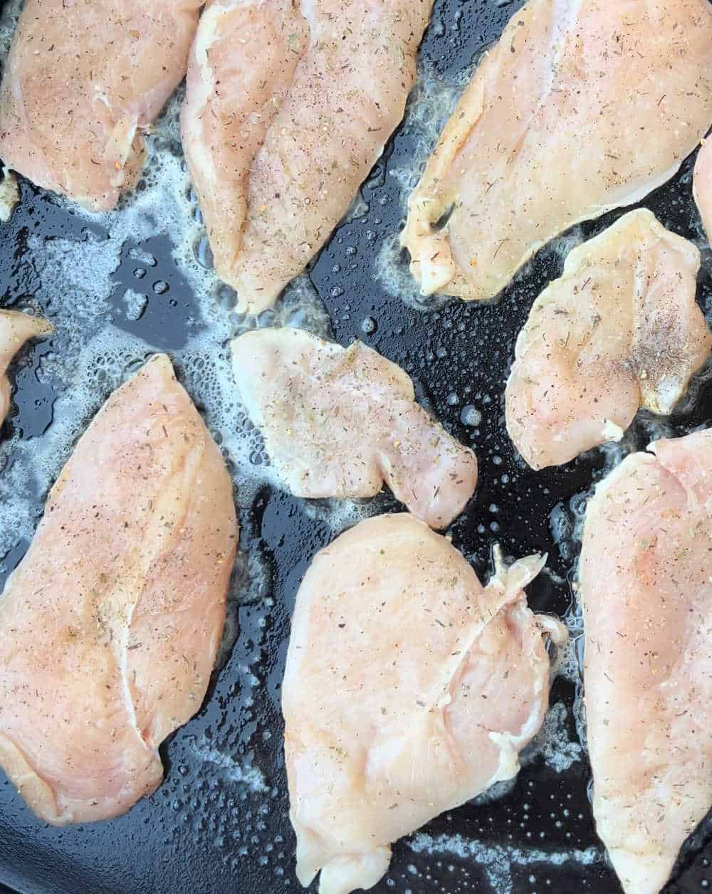 cook seasoned chicken breast on flat top grill.