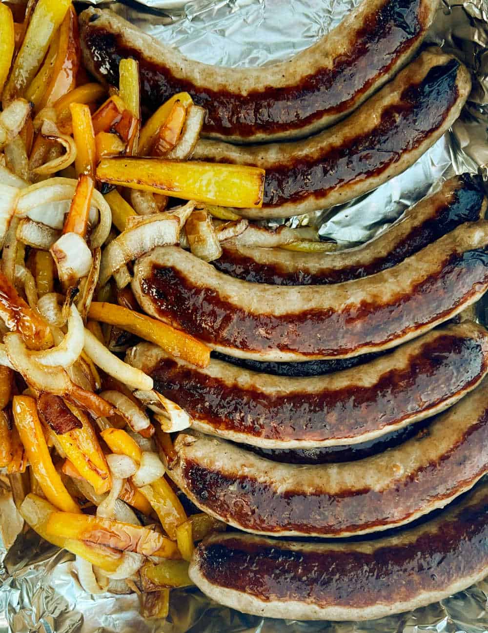 cooked sausages, peppers and onions in foil pan.