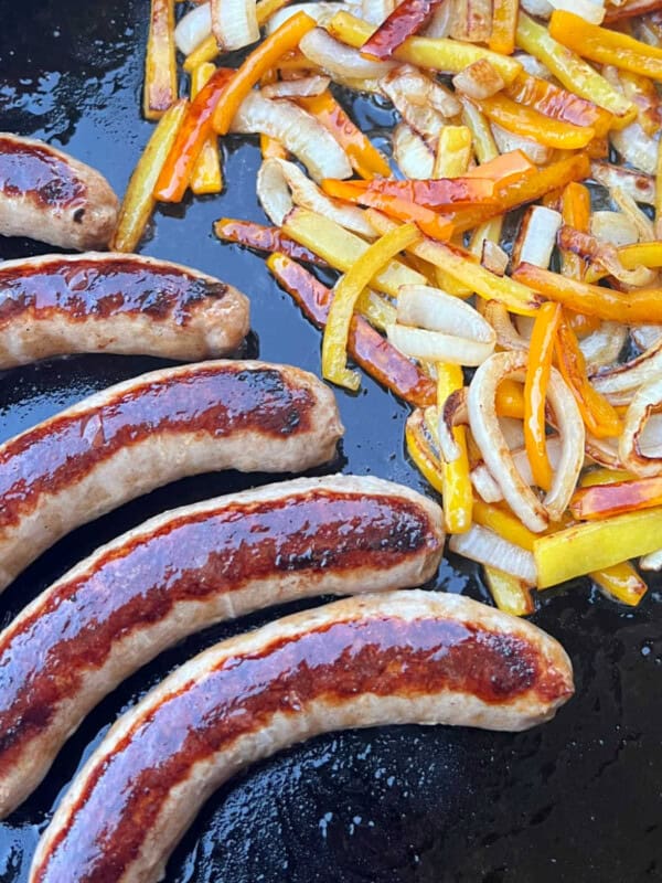 Italian sausages with peppers and onions on blackstone griddle.