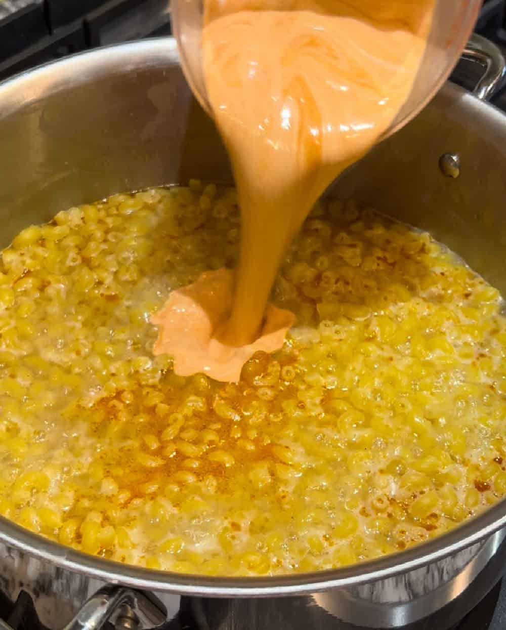 pour cream and sauce into macaroni noodles.