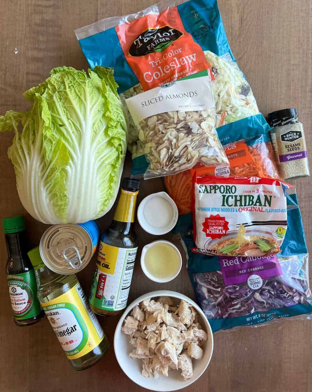 ramen noodles, napa cabbage, coleslaw mix, cooked chicken, almonds, mandarin oranges, veggies and dressing ingredients.