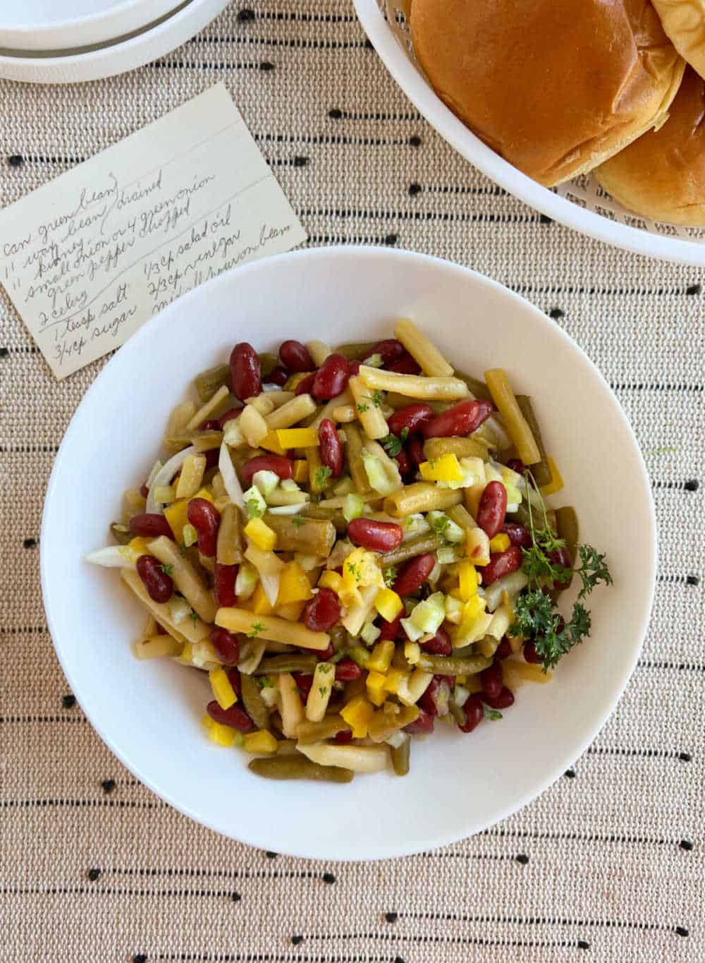 3 bean salad in bowl with handwritten recipe.