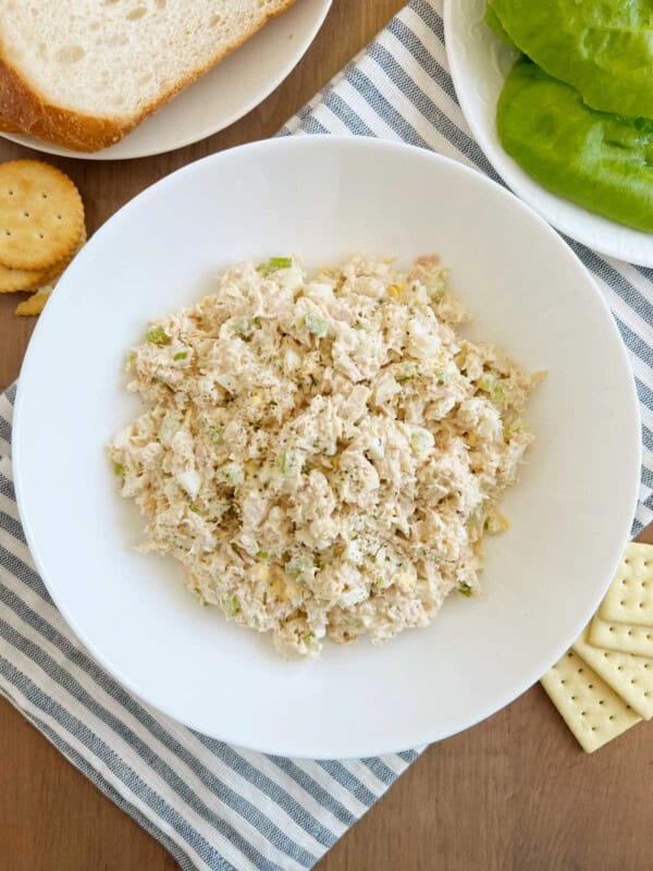 bowl of tuna salad with egg and celery on the table.