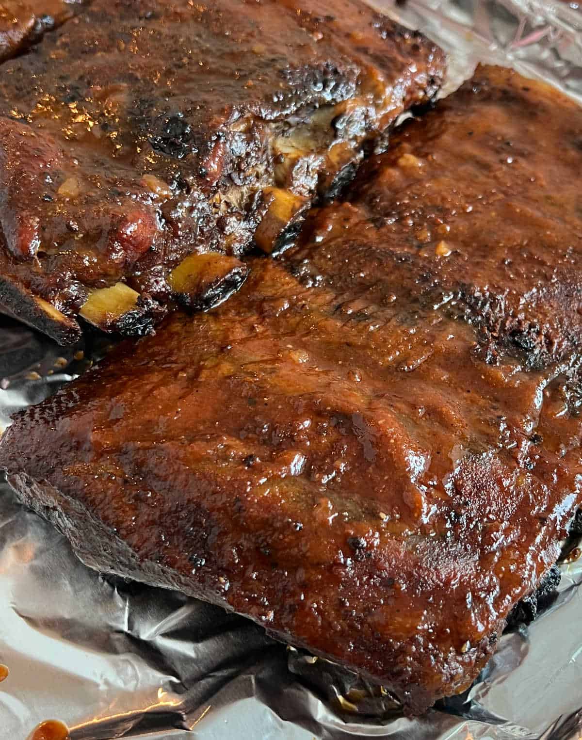 smoked St Louis ribs with bbq sauce on tray.