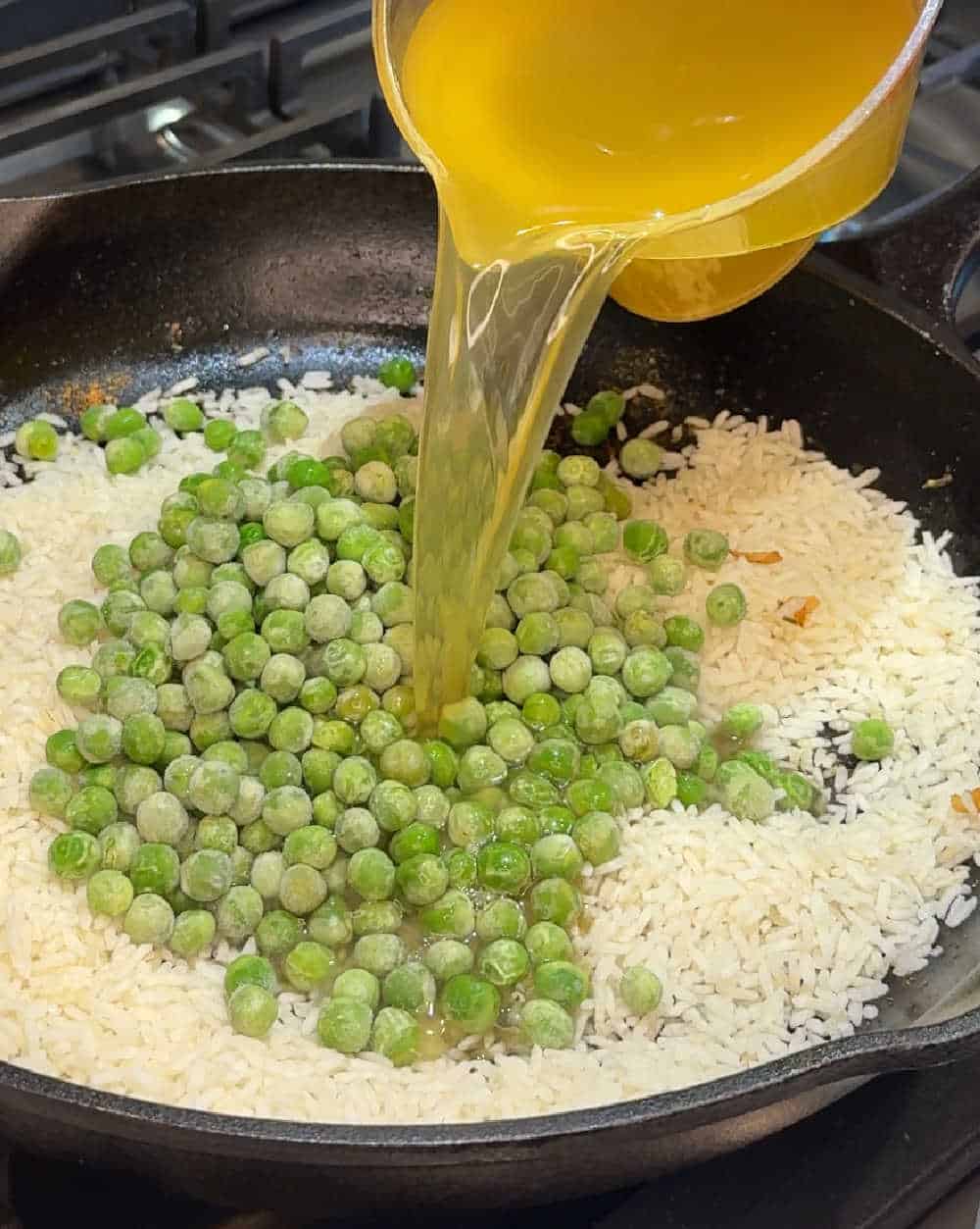 add broth to rice and peas in pan.