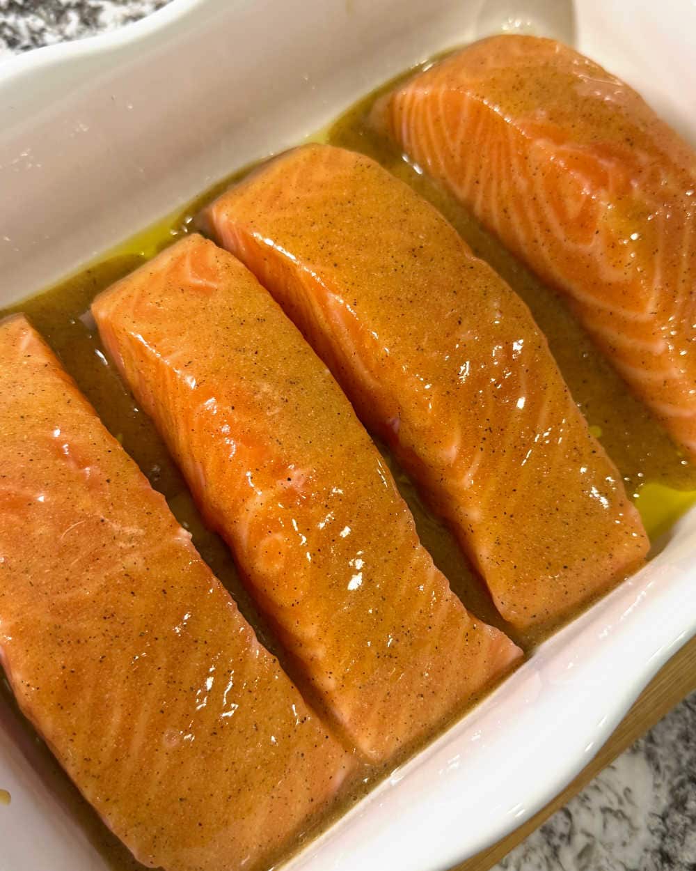 salmon fillets with sauce in white dish.