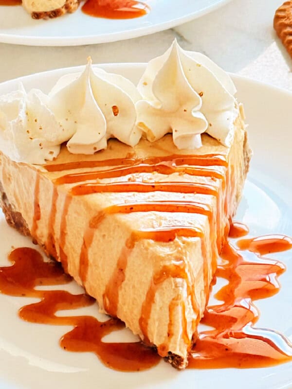 slice of Biscoff cookie butter pie with caramel sauce on a plate.