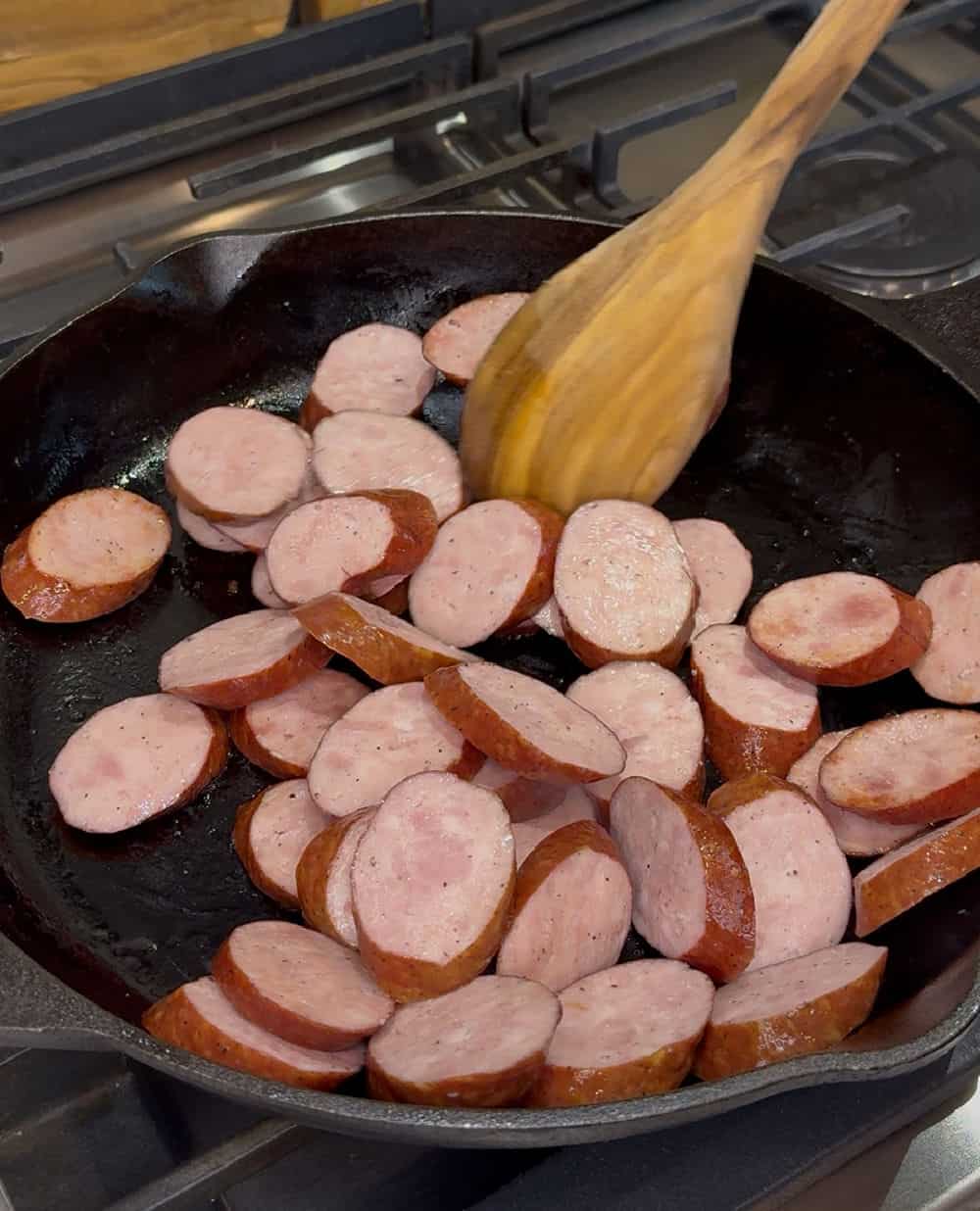 brown sausage slices in pan.