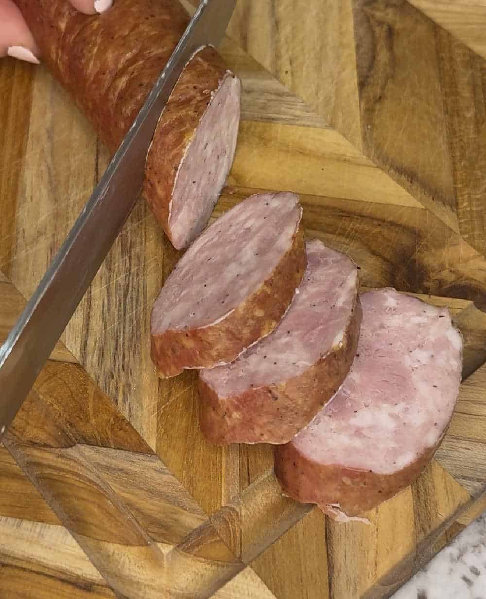 slice smoked sausage on cutting board.
