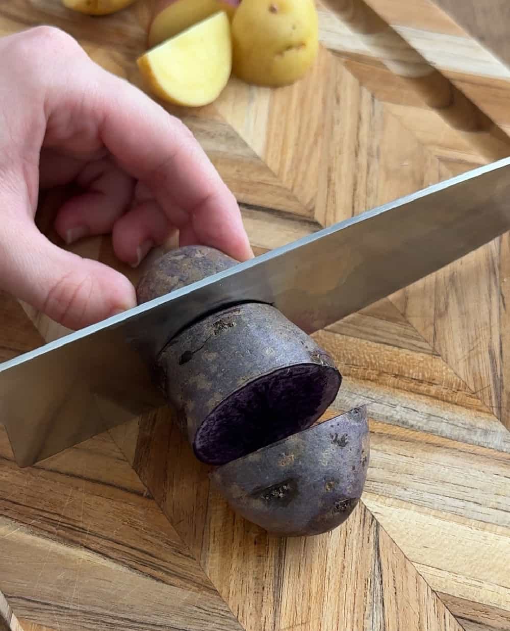 slice yellow and blue potato on cutting board.