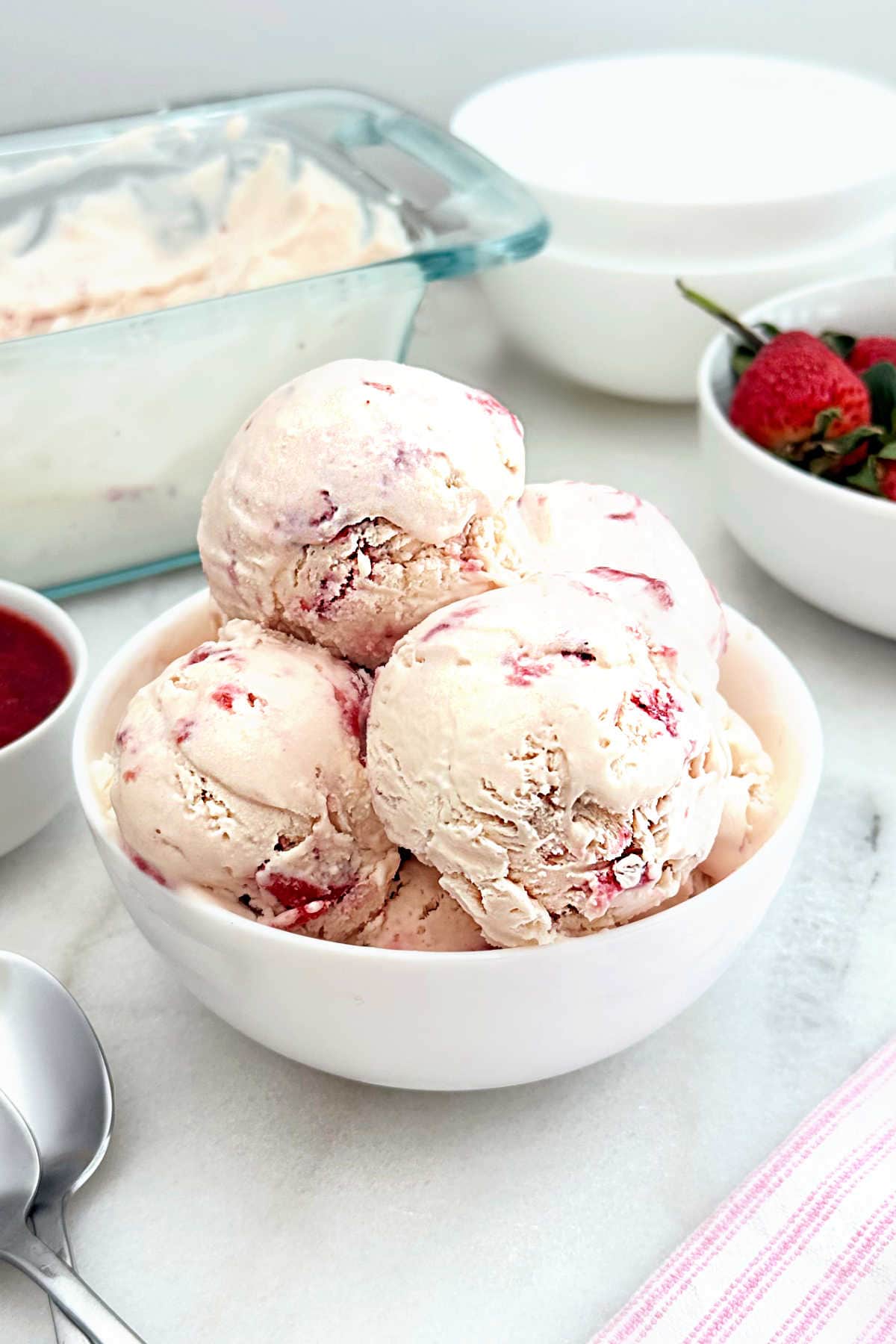 homemade strawberry ice cream in a white bowl.