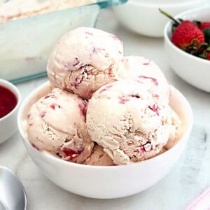 bowl of homemade strawberry ice cream with fresh strawberries.