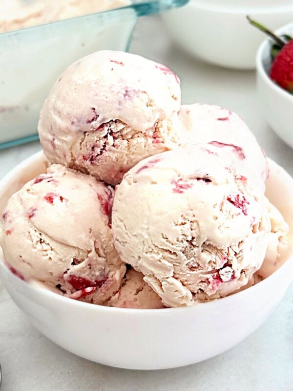 bowl of homemade strawberry ice cream with fresh strawberries.