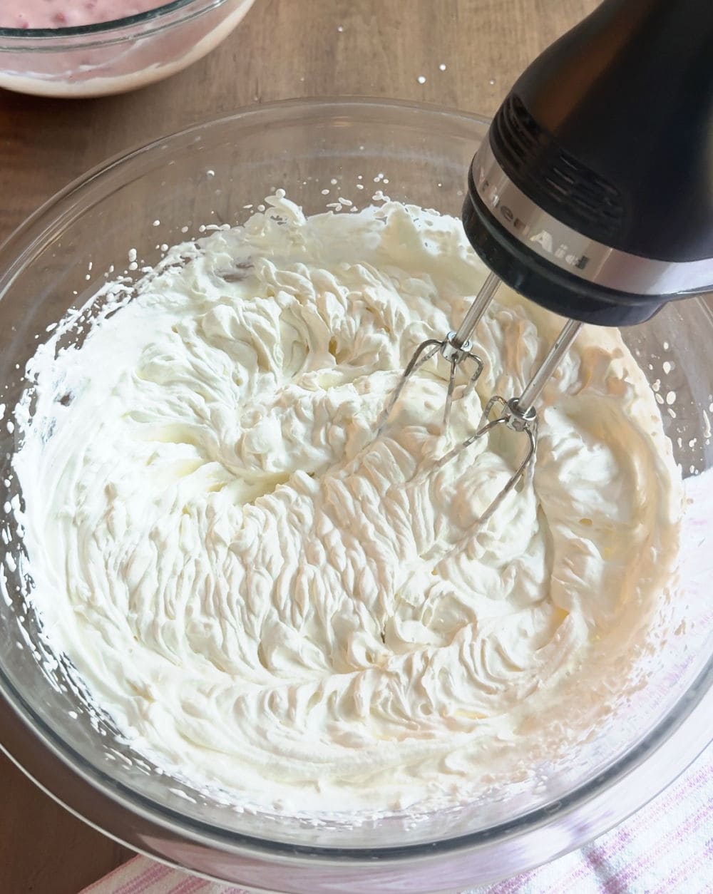 electric mixer whipped cream in bowl.