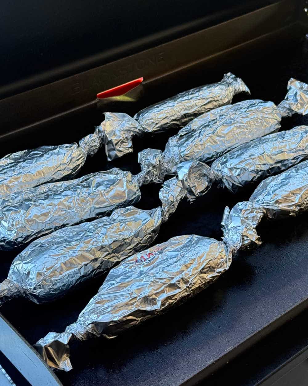foil wrapped corn on the griddle.