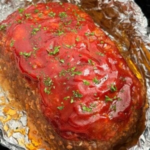 crockpot meatloaf topped with glaze and parsley.