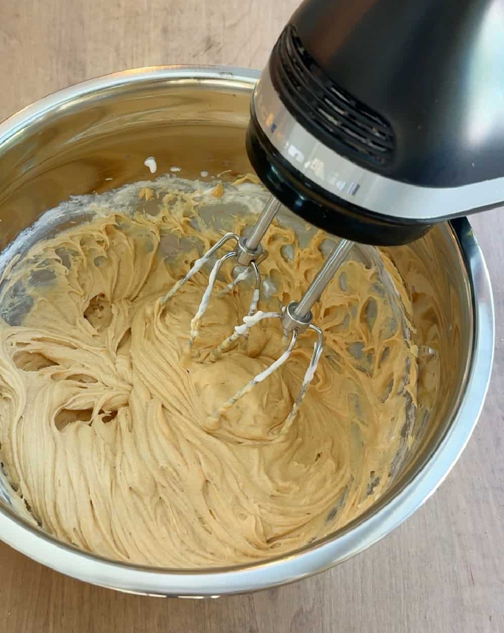 electric mixer making frosting in bowl.