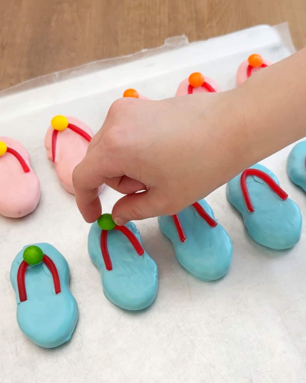 placing skittle on cookie.
