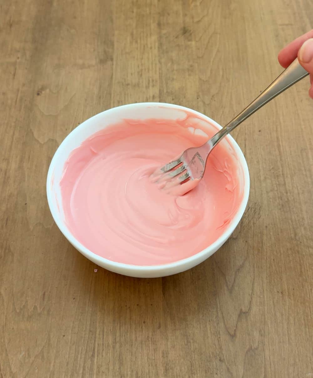 fork stirring melted candy coating.