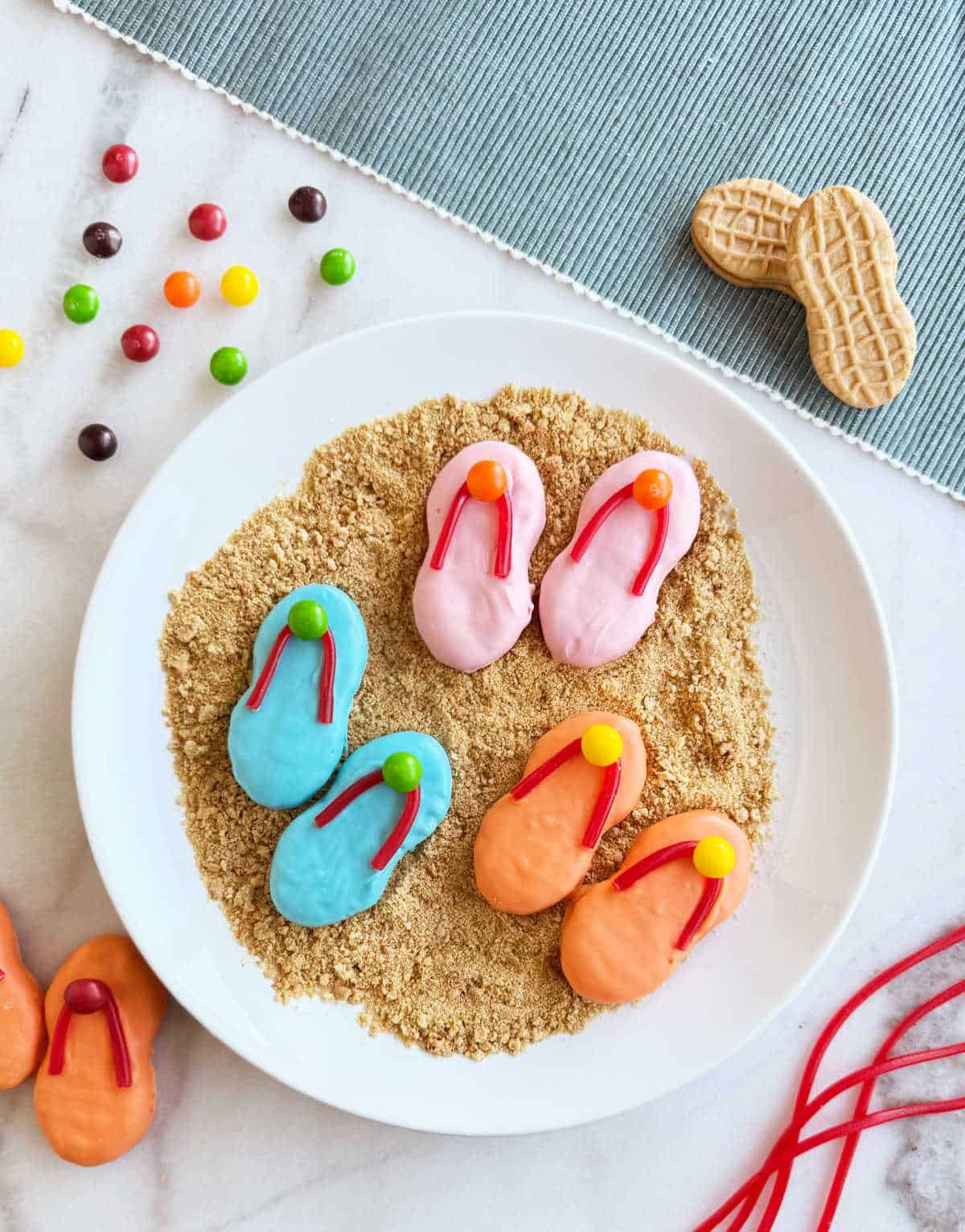 plate of flip flop cookies with on crushed graham crackers.