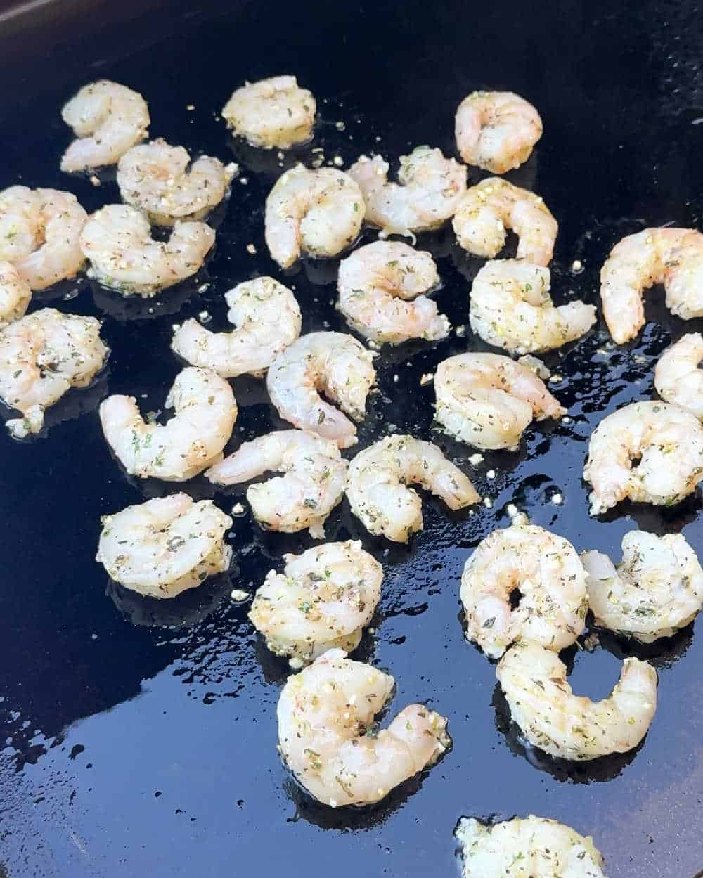 seasoned raw shrimp on griddle.