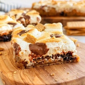 sliced s'more cookie bars on wood board.