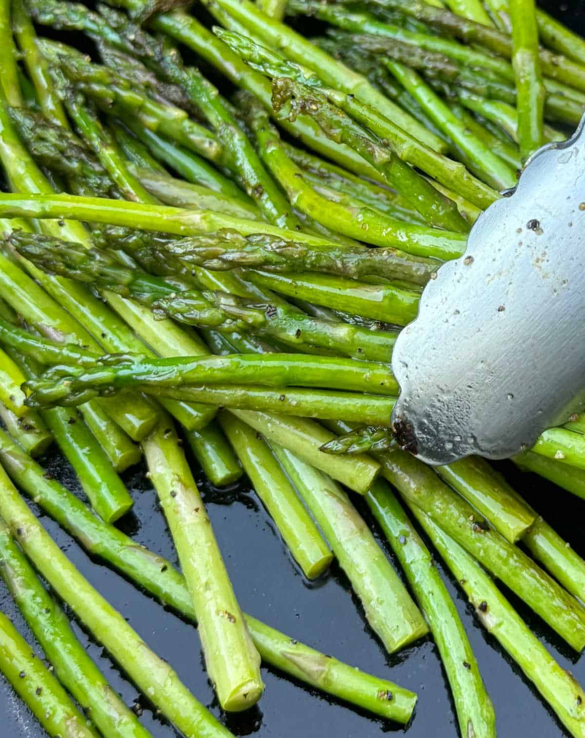 grilled asparagus in tongs.
