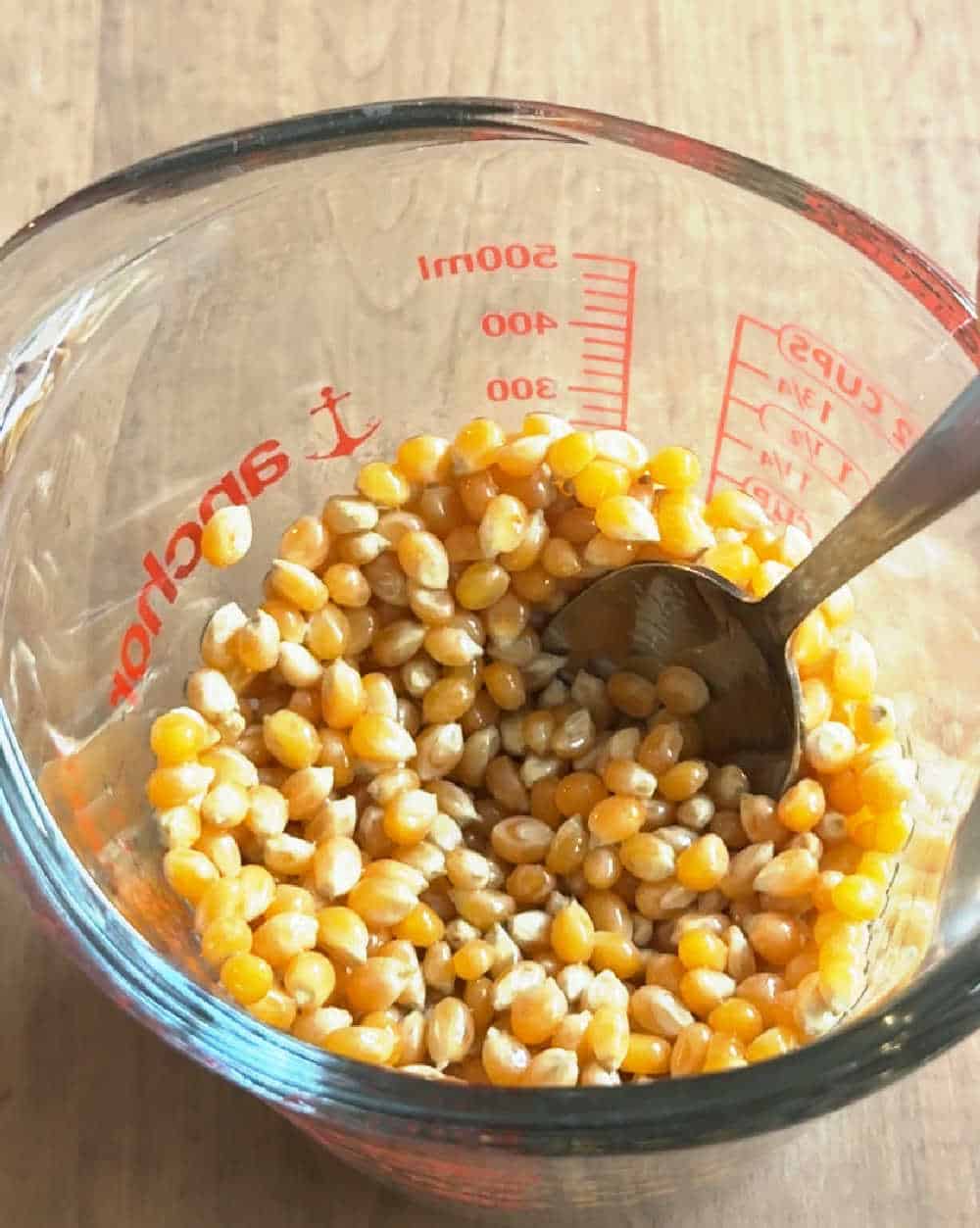 stirring corn kernels in measuring cup.