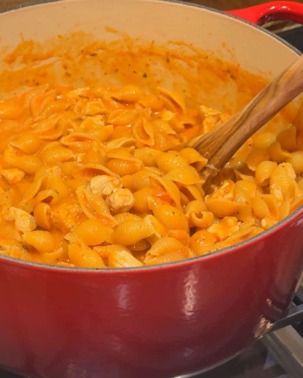 adding cream to pasta.