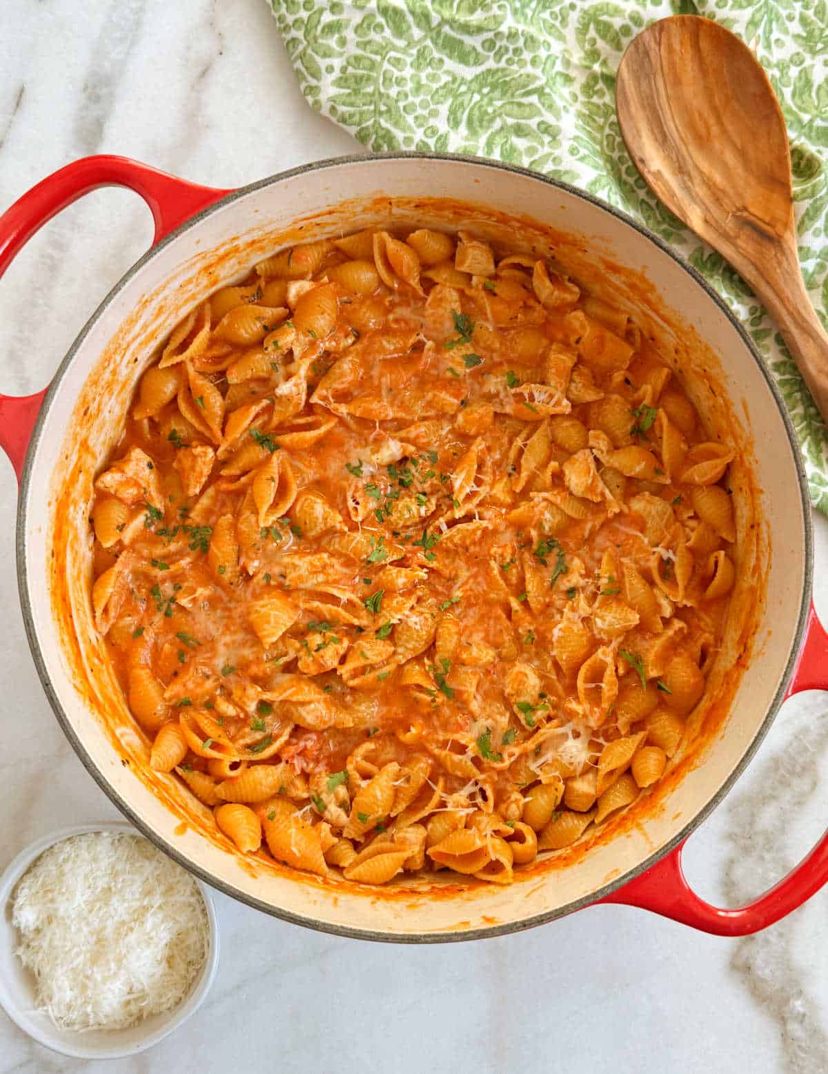 creamy chicken pasta in red Dutch oven.