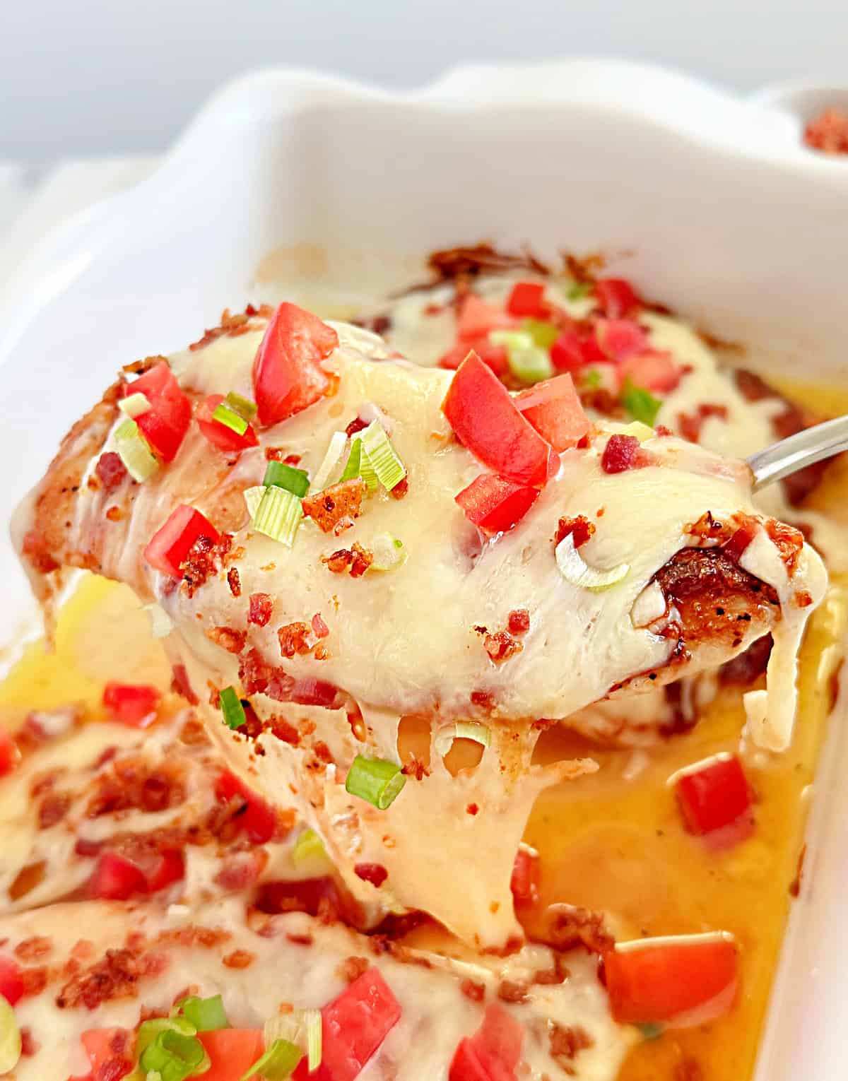 monterey chicken with melted cheese on serving spoon.