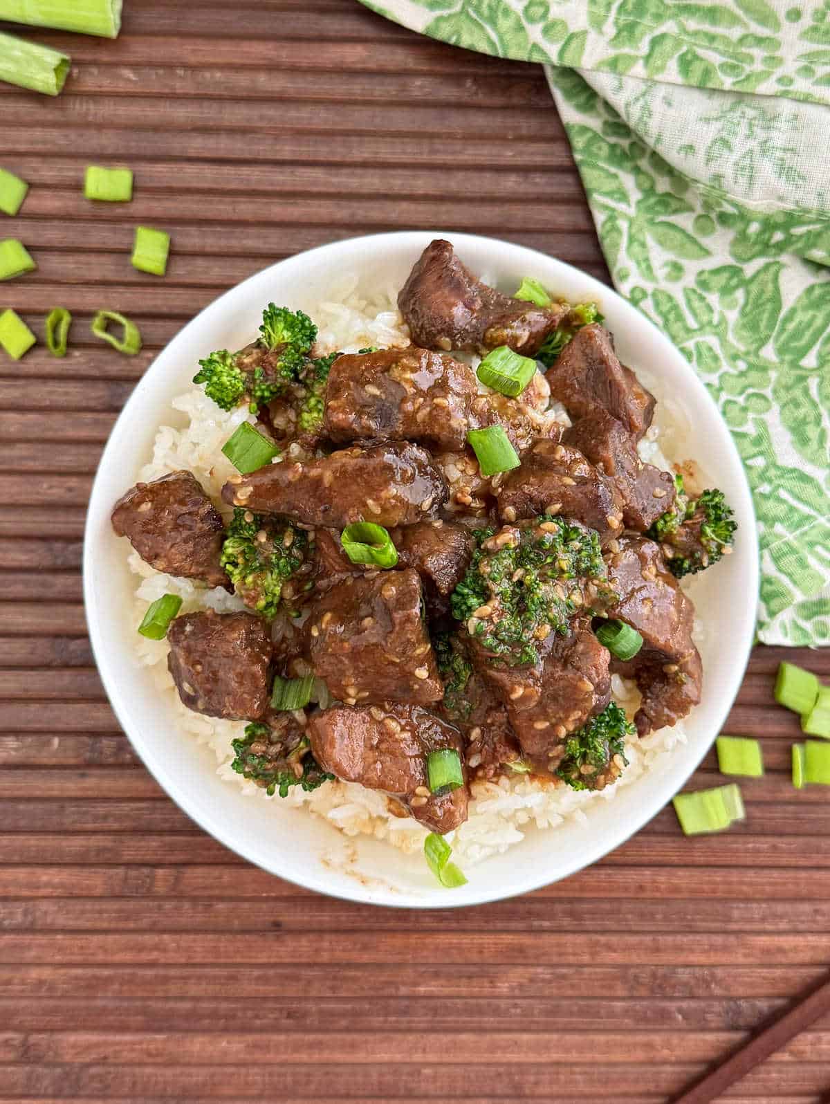 crock pot teriyaki beef bowl with rice and broccoli and scallions.
