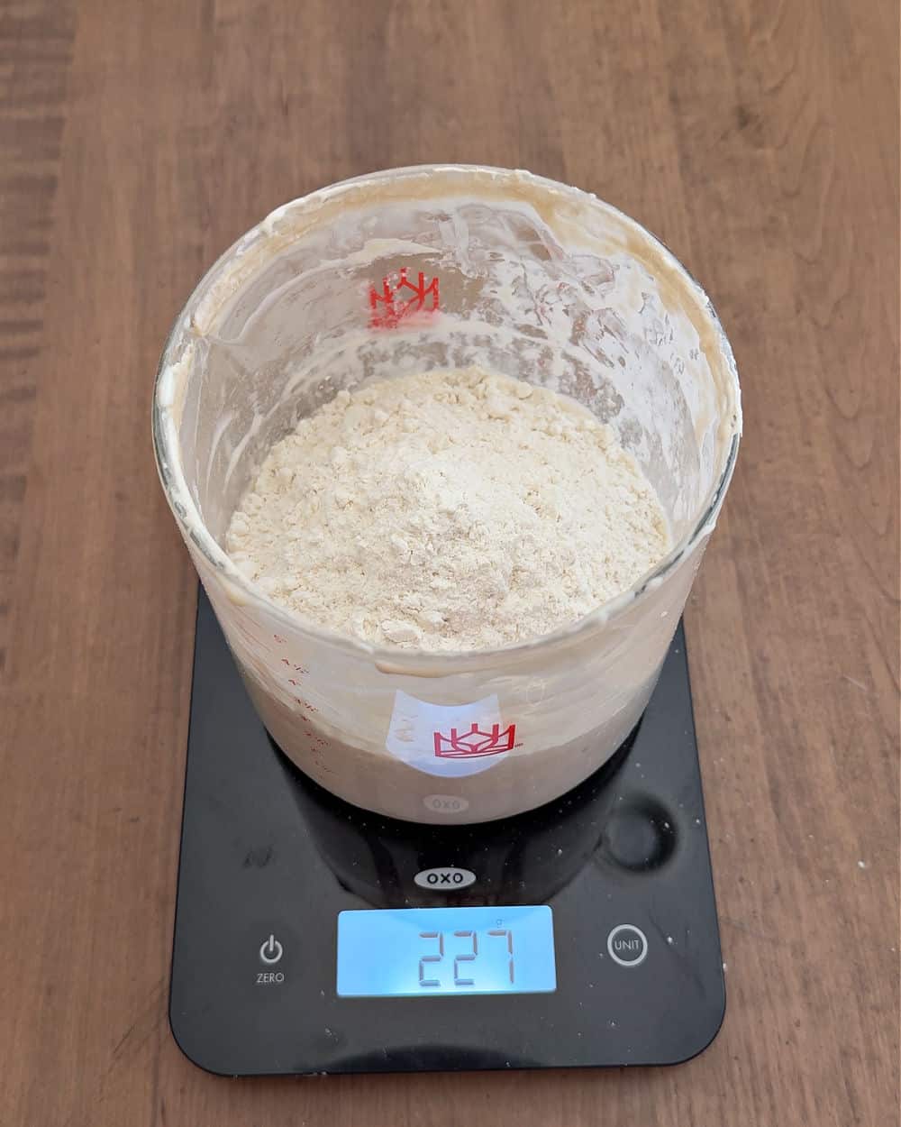 adding flour in crock on scale.