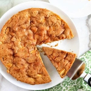 fresh apple cake with slice on cake server.