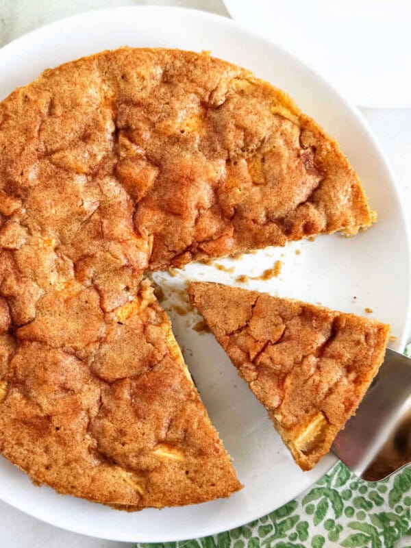 fresh apple cake with slice on cake server.