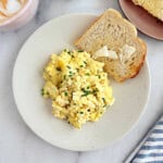 scrambled eggs with cream cheese and chives on a plate.