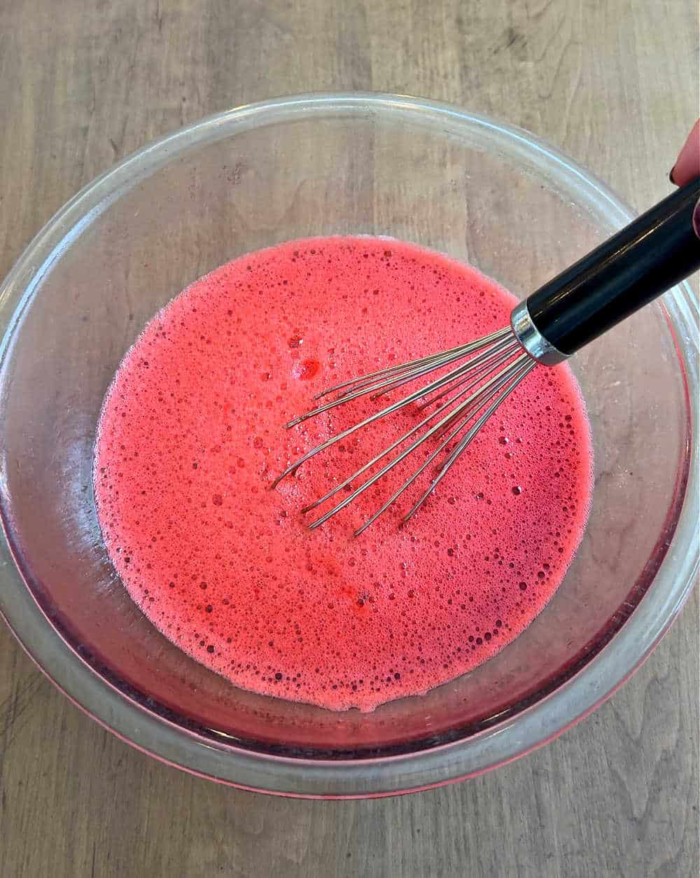 whisking water and jello in bowl.