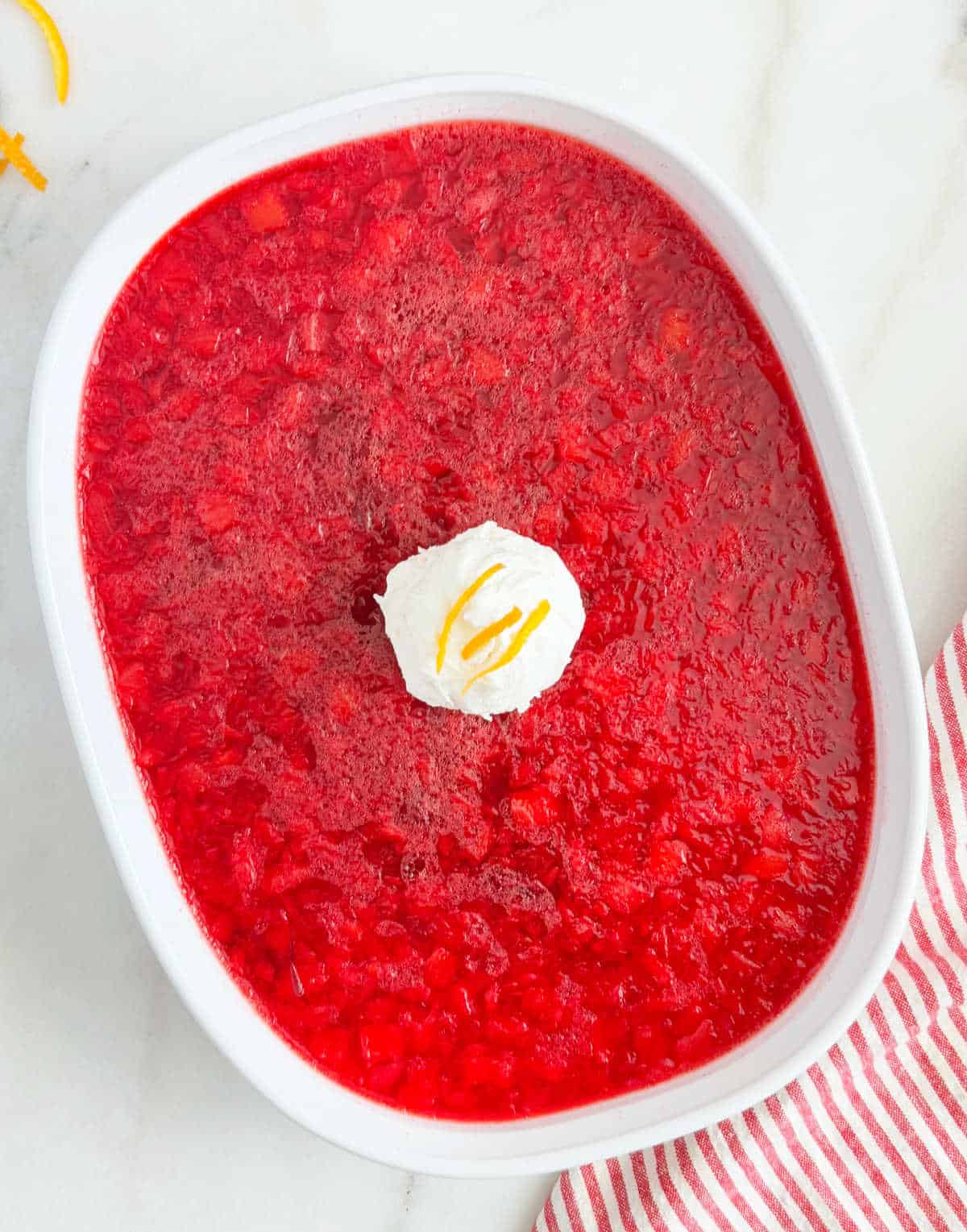 cranberry jello salad with pineapple, whipped cream and orange zest.