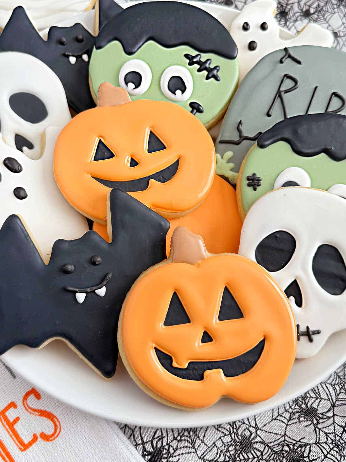 plate of cut-out halloween sugar cookies decorated with royal icing.