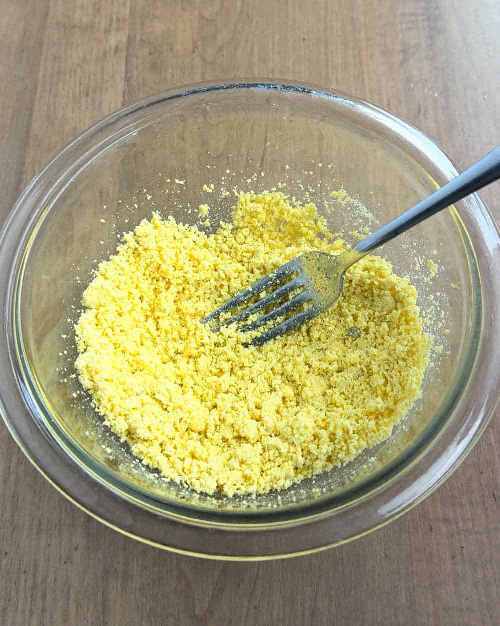 mashing egg yolks with fork.