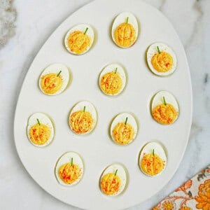 pumpkin deviled eggs in serving dish.